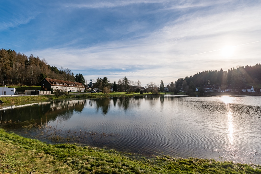 See mit Uferbebauung und bewaldeten Hügeln in Bad Grund (Harz)